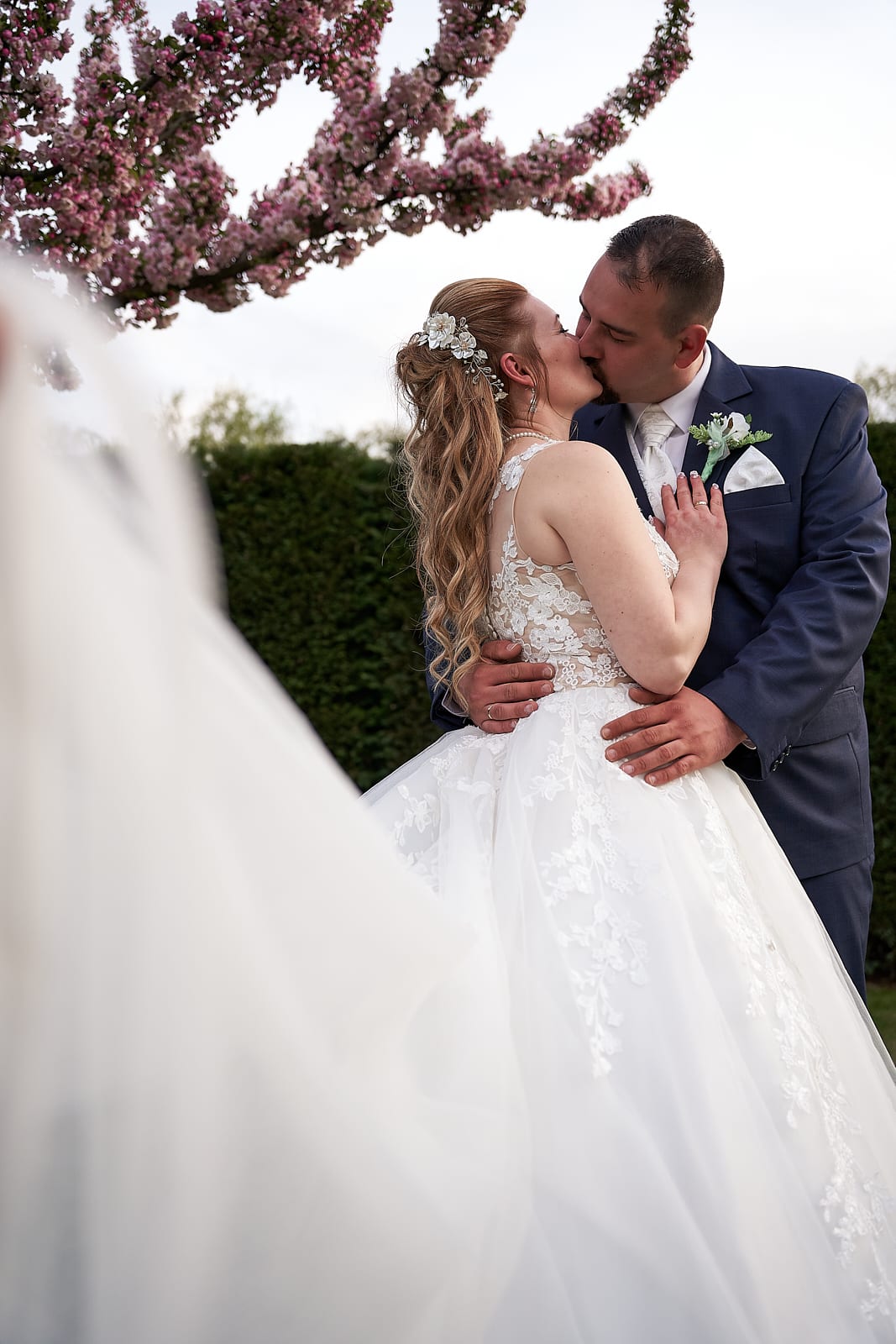 Anita és Zoli virágzó cseresznyefa előtt csókolózik